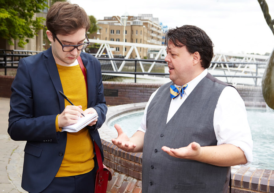 craig glenday talking to man with notepad in his hand